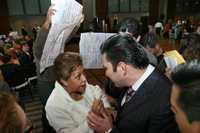 Profesores muestran pancartas de inconformidad al subsecretario Fernando González Sánchez durante una ceremonia de entrega de reconocimientos a profesores por su trayectoria