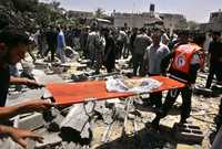 Socorristas trasladan restos de un cuerpo, cubiertos con una bandera de Hamas, luego del ataque israelí contra un centro de seguridad del Movimiento de Resistencia Islámica, ayer en el barrio de Zeitoun, en la ciudad de Gaza