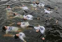 Integrantes de la organización humanitaria Médicos Sin Fronteras visten camisetas donde se lee ''VIH positivo'', mientras flotan en las aguas del Mar Báltico, cerca del puerto alemán de Rostock, como parte de una campaña del organismo para que los países en vías de desarrollo puedan tener acceso a todas las medicinas