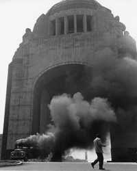 En agosto de 1958 la confluencia de situaciones, como la necesidad de los estudiantes de Derecho de la UNAM por ocupar un lugar en la sociedad de alumnos, el alza de tarifas de transporte en Monterrey y el descontento de camioneros y maestros con profundas raíces sociales dio origen a un movimiento que, aunque apenas duró dos semanas, convocó a miles de personas a diferentes mítines, la salida del Ejército a las calles y la intervención directa del entonces presidente de la República, Adolfo Ruiz Cortines. La imagen muestra una de las manifestaciones de protesta típicas de esta movilización: secuestro y quema de autobuses de transporte público, en el Monumento a la Revolución