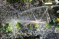 Manifestantes surcoreanos son contenidos por la policía con vallas y chorros de agua, durante una protesta frente a la casa presidencial para rechazar las importaciones de carne de res procedente de Estados Unidos