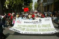 Integrantes de la sección 9 del SNTE a su paso por la calle de Donceles durante la marcha de ayer por el Centro Histórico