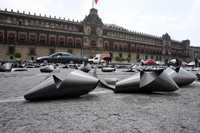 La organización no gubernamental Urbanitas colocó en el Zócalo cientos de grandes moños negros en recuerdo de las víctimas de la inseguridad imperante en el país