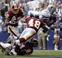 Terrell Owens, de Dallas, atrapa el ovoide entre Horton (48), McIntosh (52) y Springs